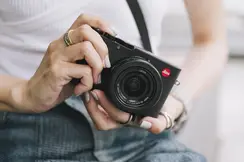 woman with a leica compact camera in his hands