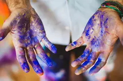 Close-up of hands smeared with blue paint.