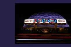 Luminous Cinerama theatre at night.