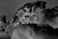 Black and white photography of jagged rock formations in a barren landscape