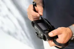 Close-up of the hands opening the back of the camera, where the camera roll is placed.