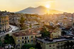 Italian city and the sun setting behind a mountain.