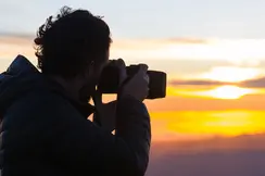 A photographer takes a photo of the sunset.