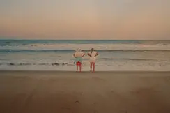 Couple standing on the beach and looking out to sea
