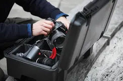 Close-up of a person taking a Leica camera out of a camera case