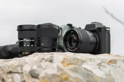 Leica cameras placed on a light-colored rock or stone with the sky in the background