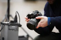 Close-up of a man holding a Leica camera in his hands