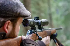 The focus is on the Leica Fortis while a hunter gazes intently through the scope