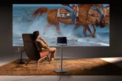 A man is sitting in front of a screen watching a Leica Cine Play 1 projection.