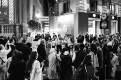 Guests at the celebrations stand in front of the Leica Store in Milan watching street musicians.