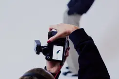 Photographer from behind in a photo studio photographing a man