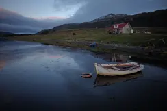 lonely house by the lake with an old boat