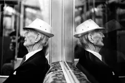Reflection of an old man sitting in the subway
