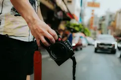 Person holding a Leica SL camera on an urban street