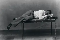 Portrait en noir et blanc de l'acteur Damson Idris allongé sur une table