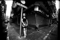 women leaning on pole street b&w