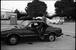 sakteboarder jumping from car b&w