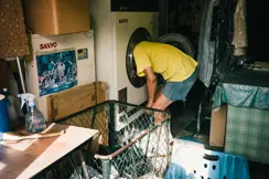 man locking into washin mashine