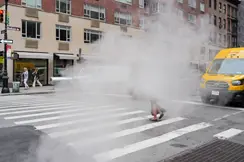 A woman walks along a pavement through the fog