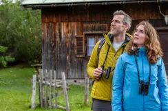 Two hikers in the mountains with their Leica Noctivid Compact