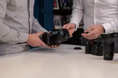 Customer exploring Leica Trade-In options while testing a Leica SL-System camera with a Leica expert.