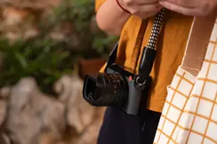 Person carrying a Leica camera while exploring outdoors