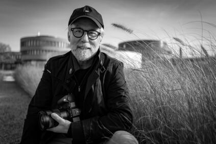 Portrait of photographer Ragnar Axelsson holding a Leica camera