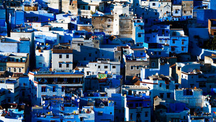 A cityscape with many blue and white houses standing close together.