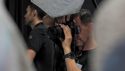 Close-up of a man taking a picture in a studio.