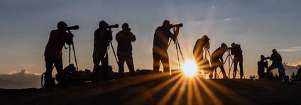 Photographers lined up captured against the sunlight