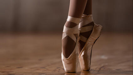 Close-up of a ballerina's feet in ballet shoes.