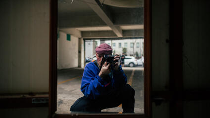 A man takes a picture of himself in a mirror in a garage.