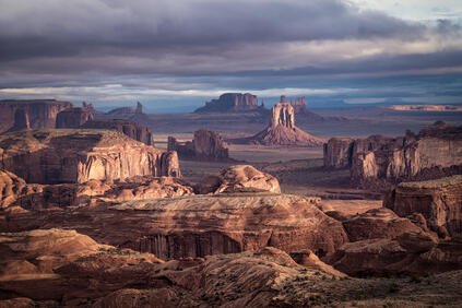 Vast desert landscape with remarkable rock formations under a cloudy sky.