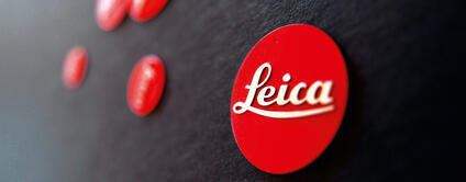 Close-up of the red Leica logo on a black background