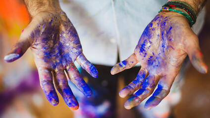 Close-up of hands smeared with blue paint.