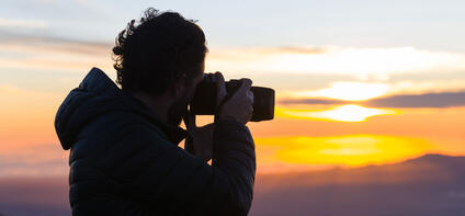 A photographer takes a photo of the sunset.