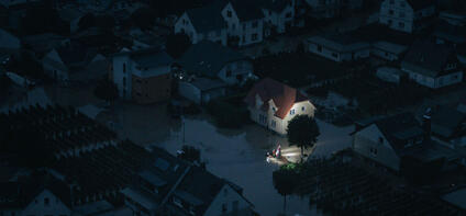 Night shot of a flooded city and rescue workers are in focus.