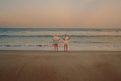 Couple standing on the beach and looking out to sea