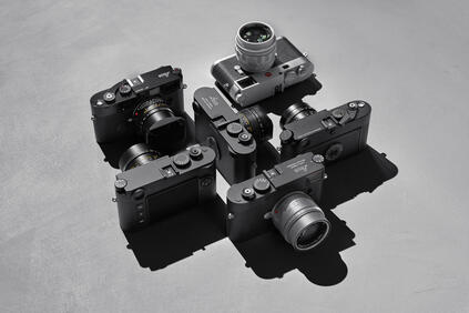 Top view of several Leica cameras on a gray background