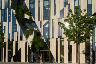 Window front of a big building with trees and plants.