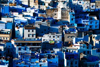 A cityscape with many blue and white houses standing close together.