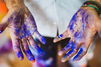 Close-up of hands smeared with blue paint.