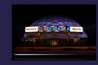 Luminous Cinerama theatre at night.