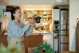 Smiling woman taking a picture of a plant in a food store.
