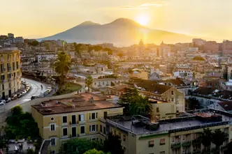 Italian city and the sun setting behind a mountain.