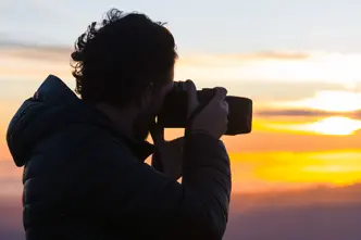 A photographer takes a photo of the sunset.