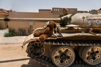 Teddy bear sitting on a tank