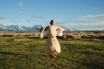 Happy woman with white dress on a meadow