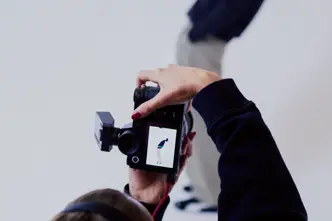 Photographer from behind in a photo studio photographing a man