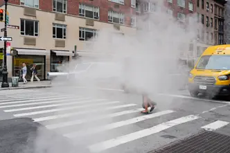 A woman walks along a pavement through the fog